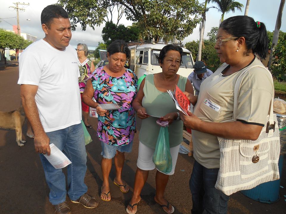 (direita da foto) Amélia orienta moradores no combate à dengue