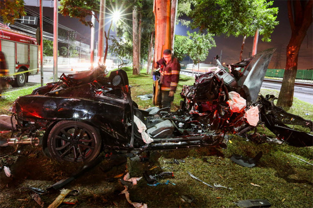 Bombeiro observa Camaro destruído após acidente que deixou duas pessoas feridas em São Paulo