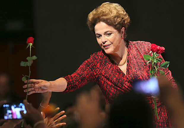 A presidente Dilma Rousseff recebe flores da plateia durante ato em Brasília