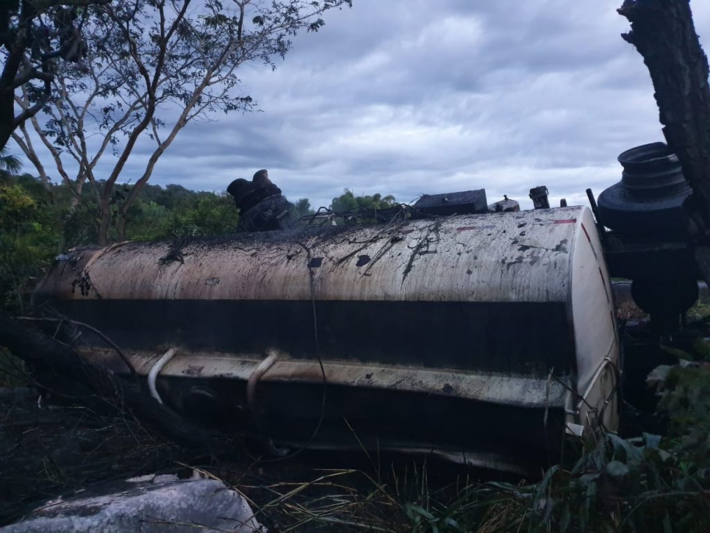 Carreta bitrem carregada com combustível pegou fogo ao tombar às margens pista