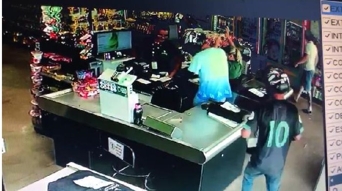 Bandido rende dois homens que estavam no parte externa de um dos supermercados (Foto: Reprodução do sistema de segurança)