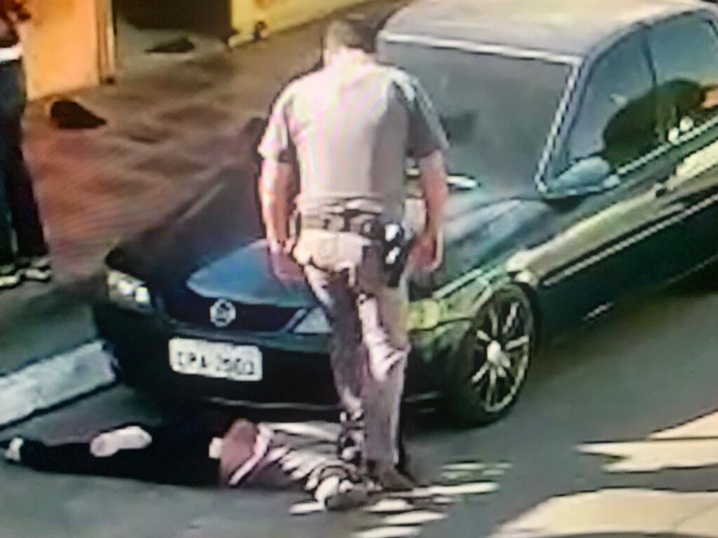 Policial Militar pisando no pescoço de mulher negra